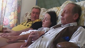 Impossibly naughty coed is playing with two rigid cocks on the couch